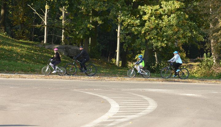 Rodzina na rowerach jadąca po ścieżce rowerowej w gminie Wiązowna