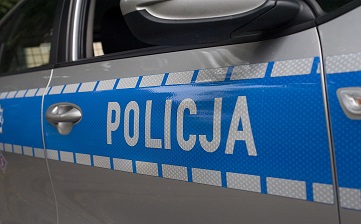 Fragment samochodu policyjnego. biały napis policja na niebieskim pasie