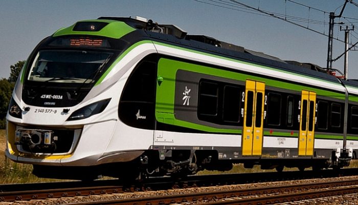 Biało-zielono-żółty pociąg Kolei Mazowieckich.