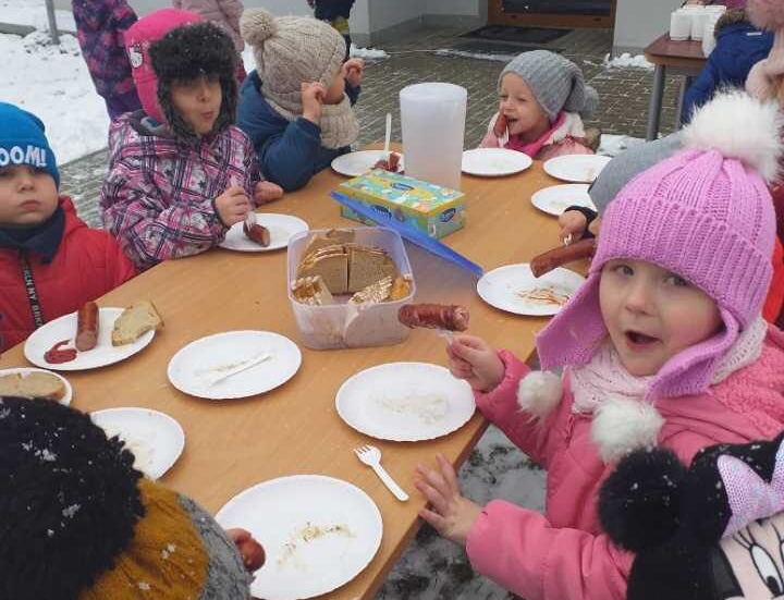 Dzieci jedzące pieczoną kiełbaskę