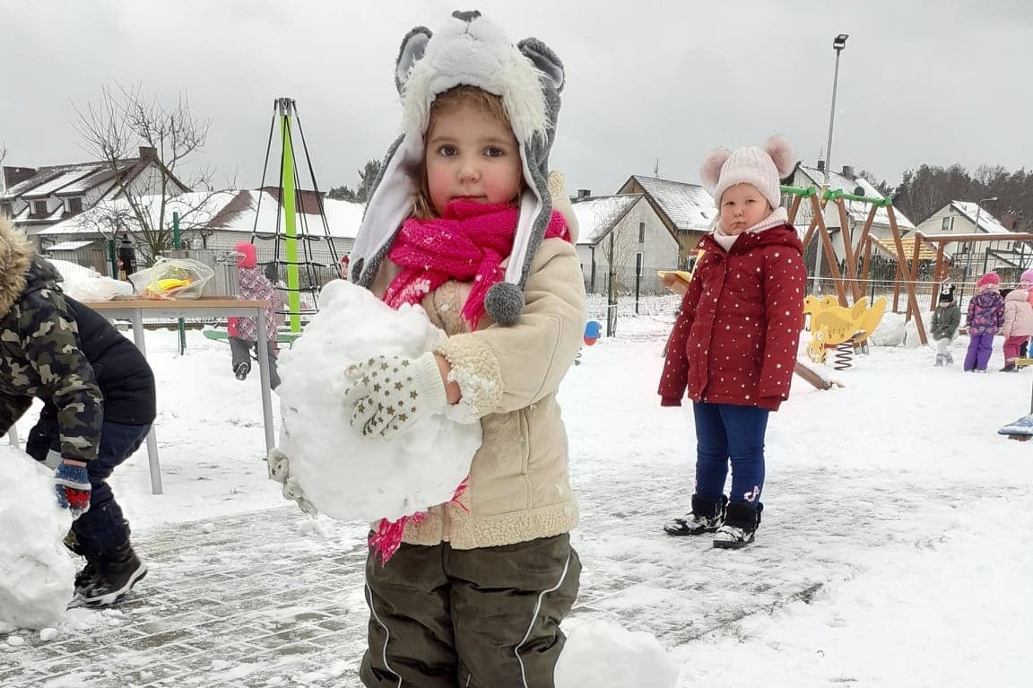 Dziewczynka trzyma dużą kulę śnieżną