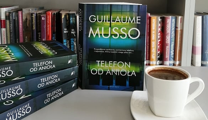 Okładka książki Guillaume Musso "Telefon od anioła". Obok kawa w białej filiżance