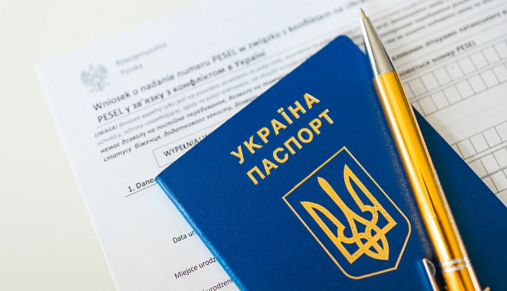 Paszport ukraiński, żółty długopis i wniosek o wydanie numeru PESEL