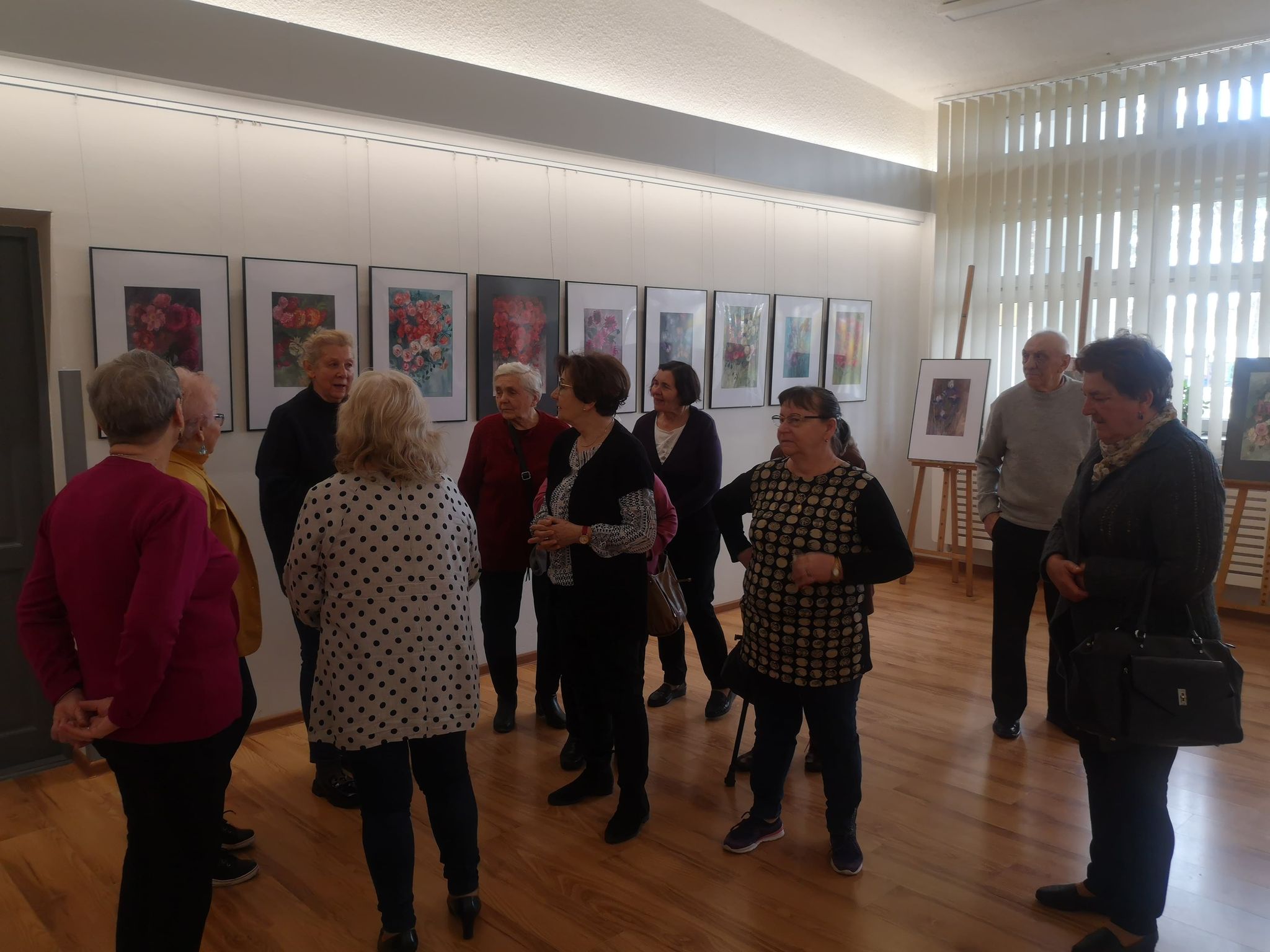 Seniorzy podziwiają wystawę prac Bożeny Stawikowskiej
