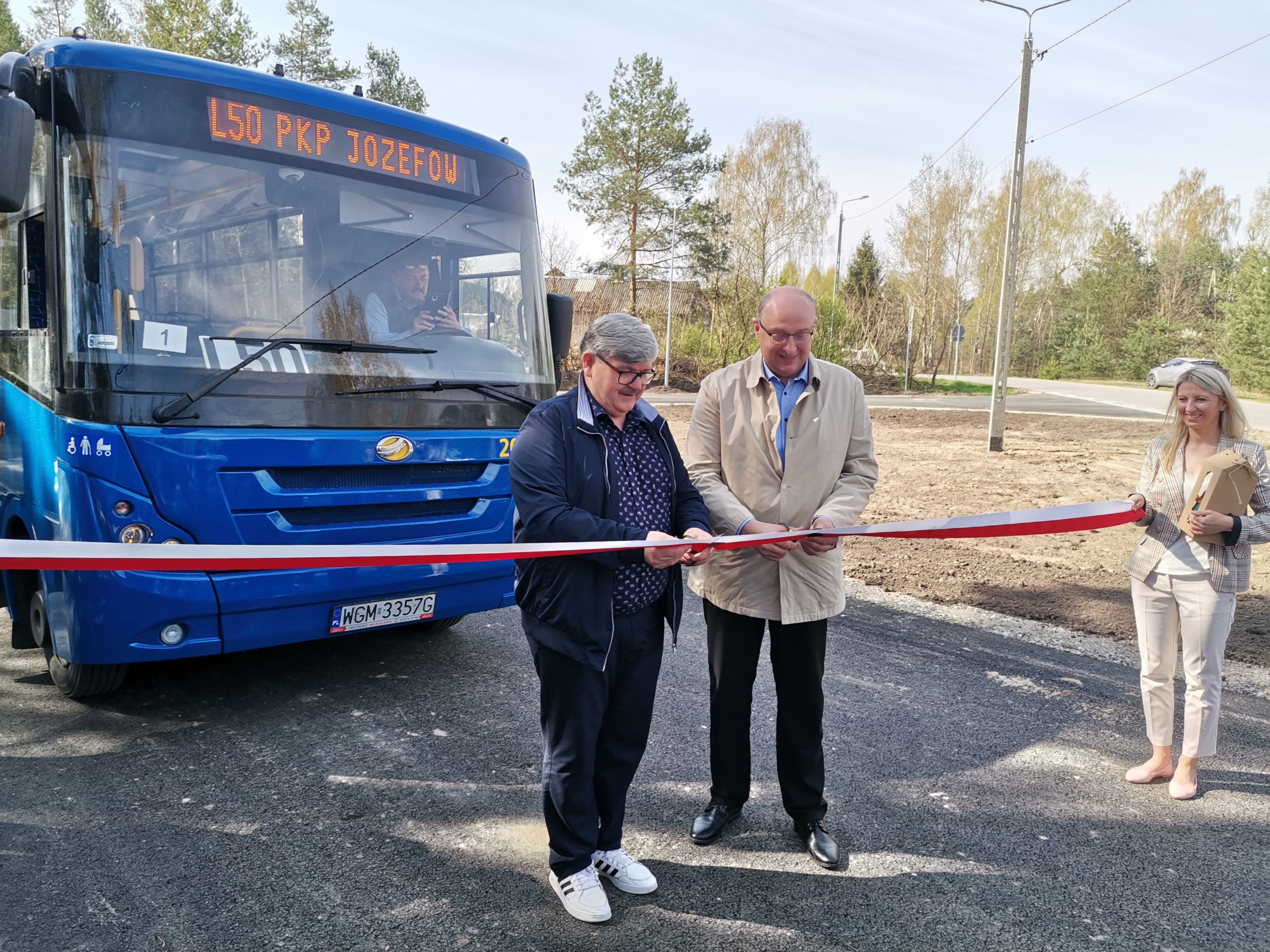 Przecięcie biał-czerwonej wstęgi przez wójta Janusza Budnego i burmistrza Marka Banaszka. W tle niebieski autobus L50.