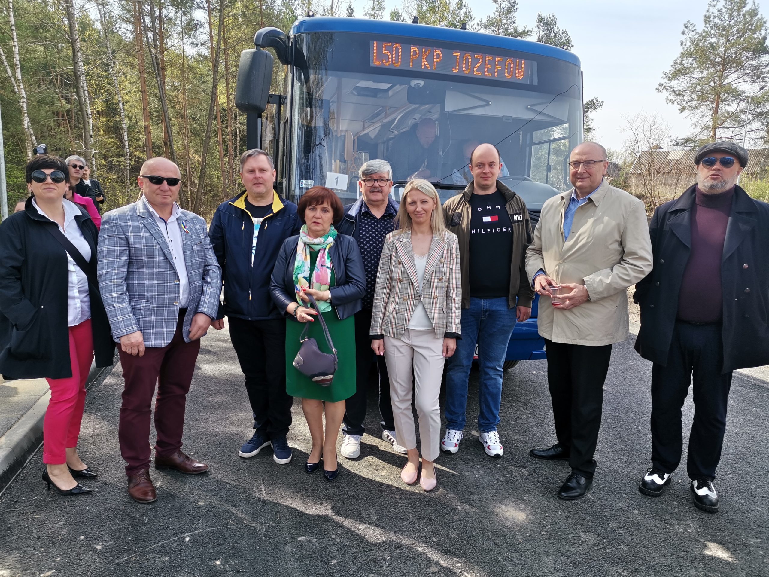 Samorządowcy Gminy Wiązowna i Miasta Jóżefów pozują przed niebieskim autobusem.