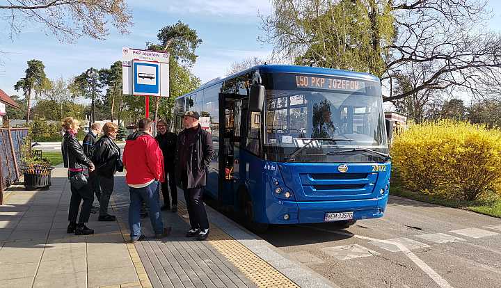 Pętla uatobusowa w Józefowie. Kilka osób stoi przy niebieskim autobusie.