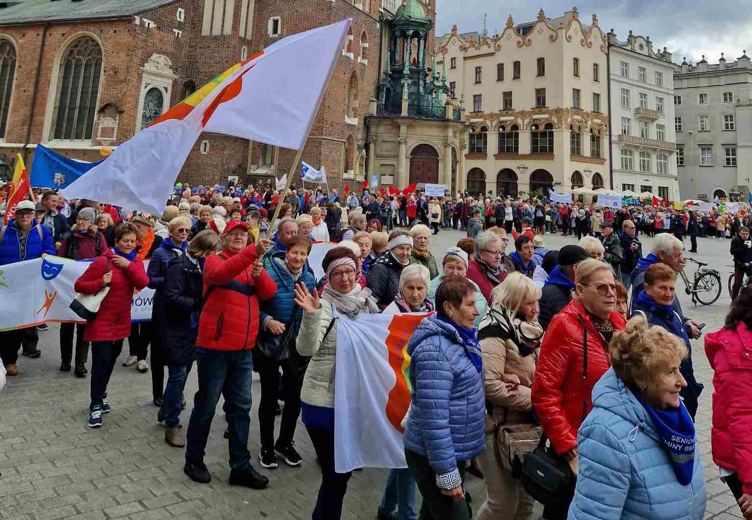 Przedstawiciele Rady Seniorów Gminy Wiązowna wzięli udział w IX Międzynarodowych Senioraliach w Krakowie. Maszerują z flagą z herbem Gminy Wiązowna
