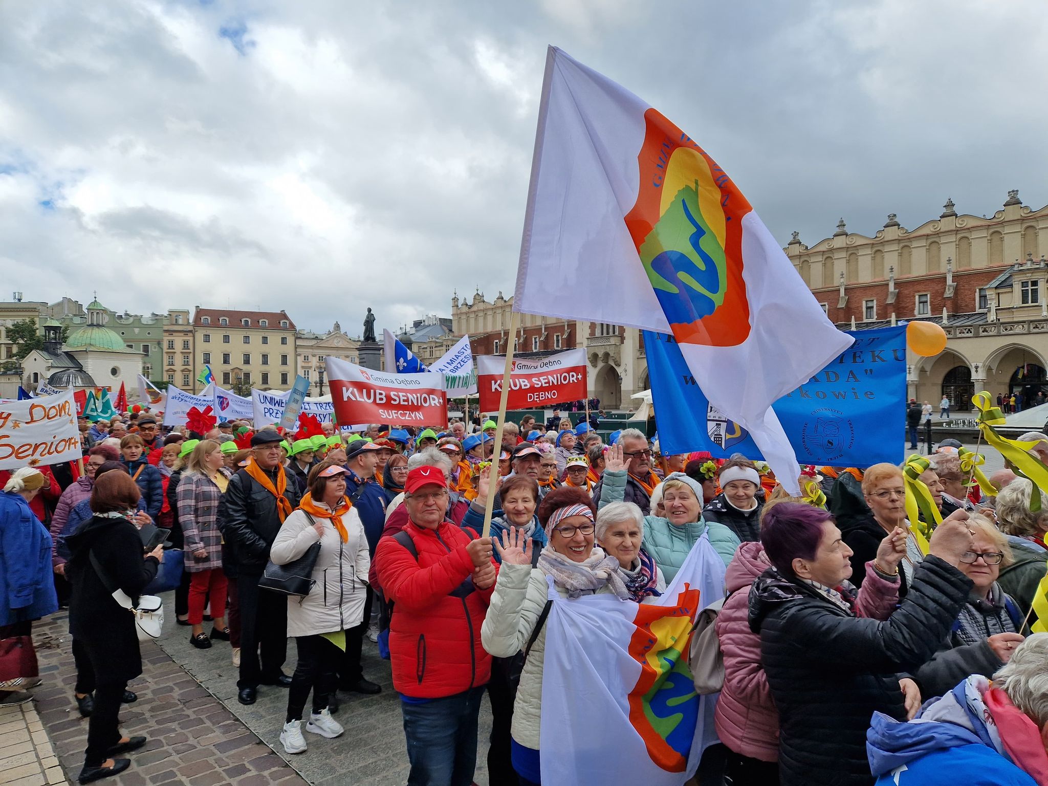 Przedstawiciele Rady Seniorów Gminy Wiązowna wzięli udział w IX Międzynarodowych Senioraliach w Krakowie. Maszerują z flagą z herbem Gminy Wiązowna