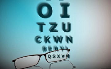 Okulary. w tle tablica z literami do badania wzroku.